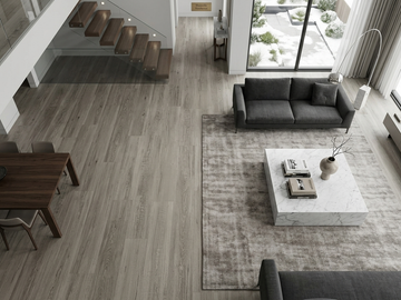Dentine SPC vinyl flooring, shown in a living room beside a staircase and dark sofa.