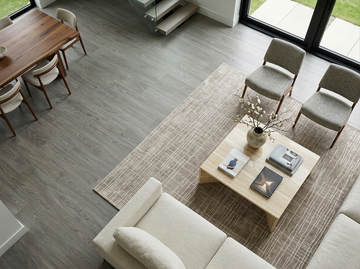 Everest SPC vinyl flooring, shown between a dining table and seating area.