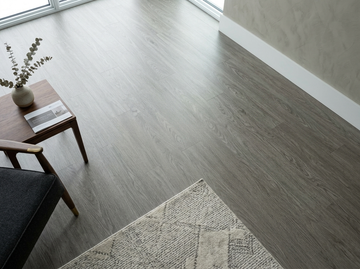 Everest SPC vinyl flooring, close view beside a side table, rug and window.