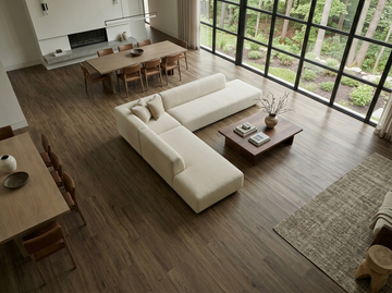 Milk Chocolate SPC vinyl flooring, shown in an open living and dining area with a white sofa.