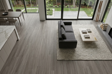 Mink SPC vinyl flooring, shown in an open living and dining area with garden windows.